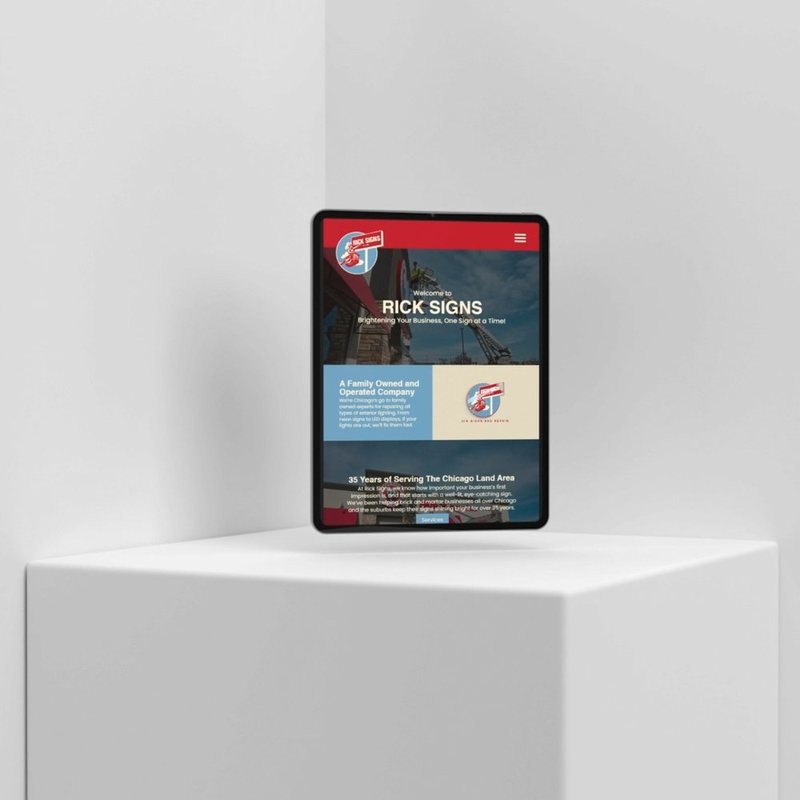 Tablet on a white pedestal displaying the Rick Signs website with red header and logo.