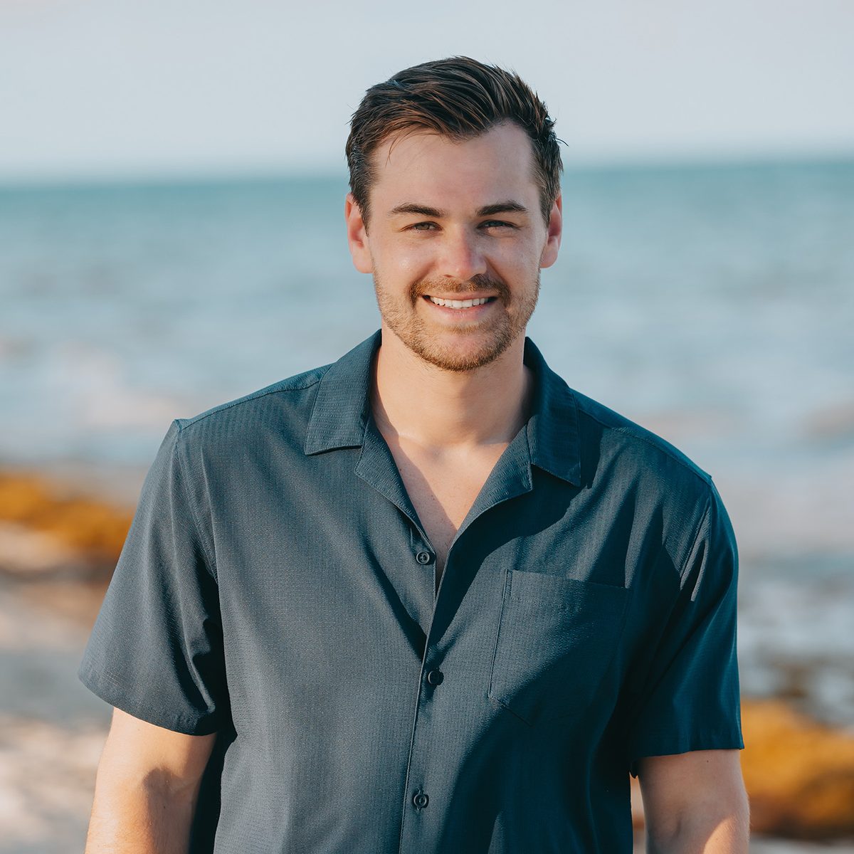 Ashton Clow, owner of Identity Start, smiling on a beach