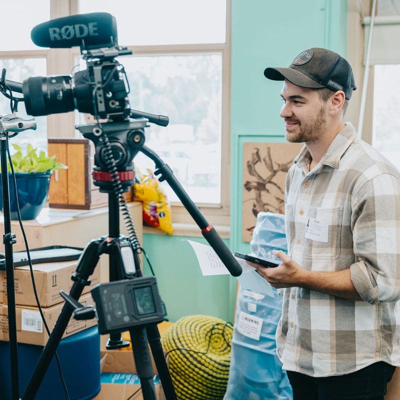 Videographer setting up a camera and microphone for an interview shoot