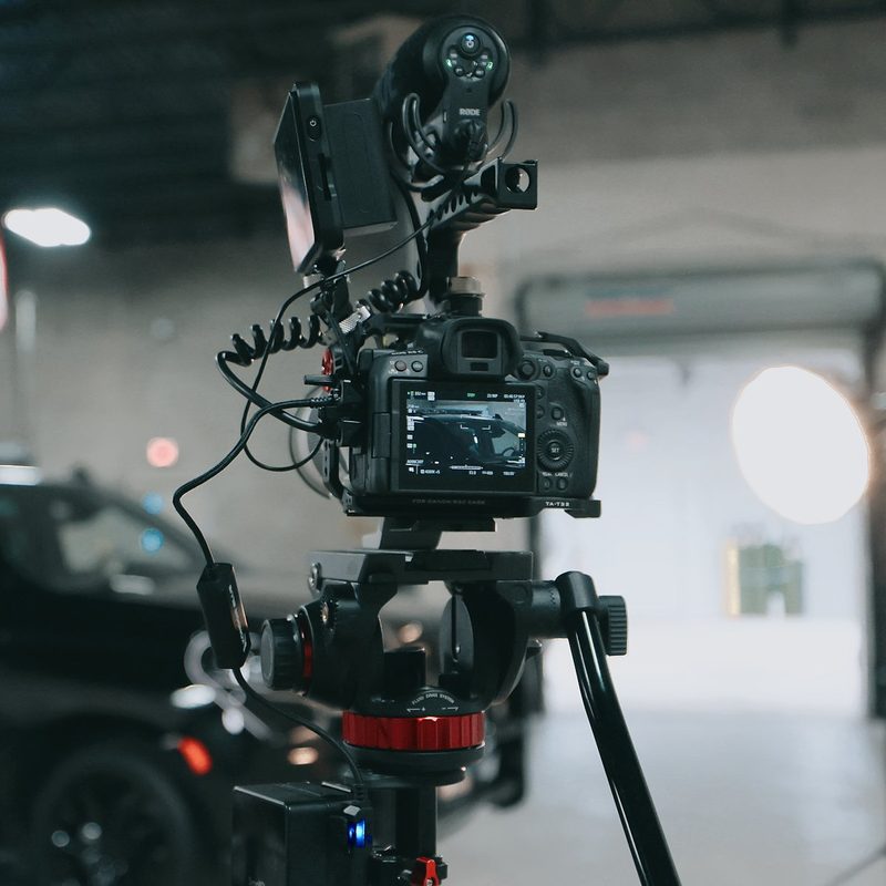 Cinema camera rig on a tripod on a Northwest Rescue video set, with the ambulance SUV behind