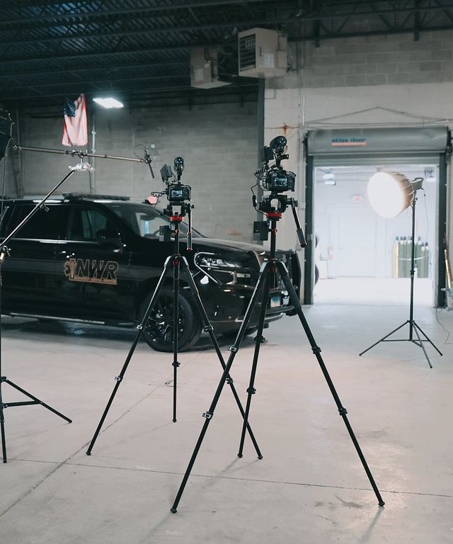 Full video set with lights and tripods around a Northwest Rescue SUV in a warehouse