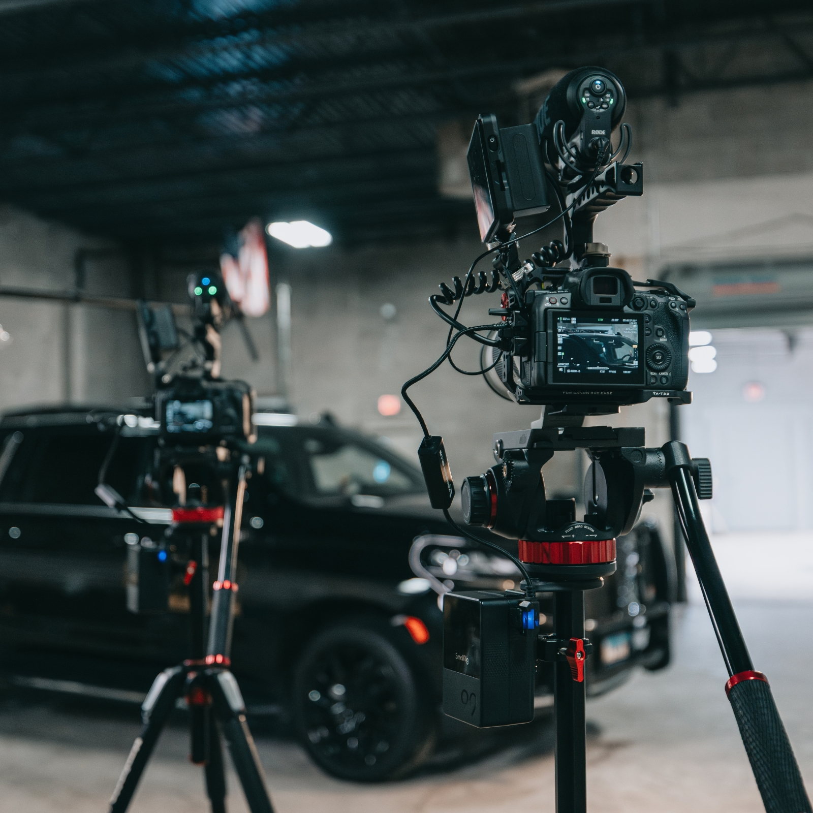 Two cinema cameras on tripods lit and set up around an ambulance for an Identity Start video shoot.