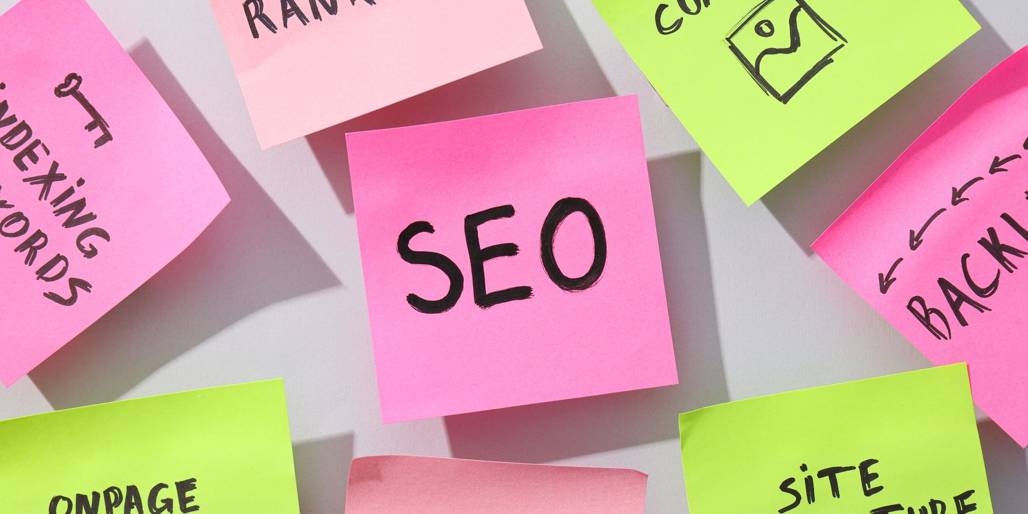 Sticky notes labeled SEO, rankings, keywords, backlinks, content and site architecture on a white wall