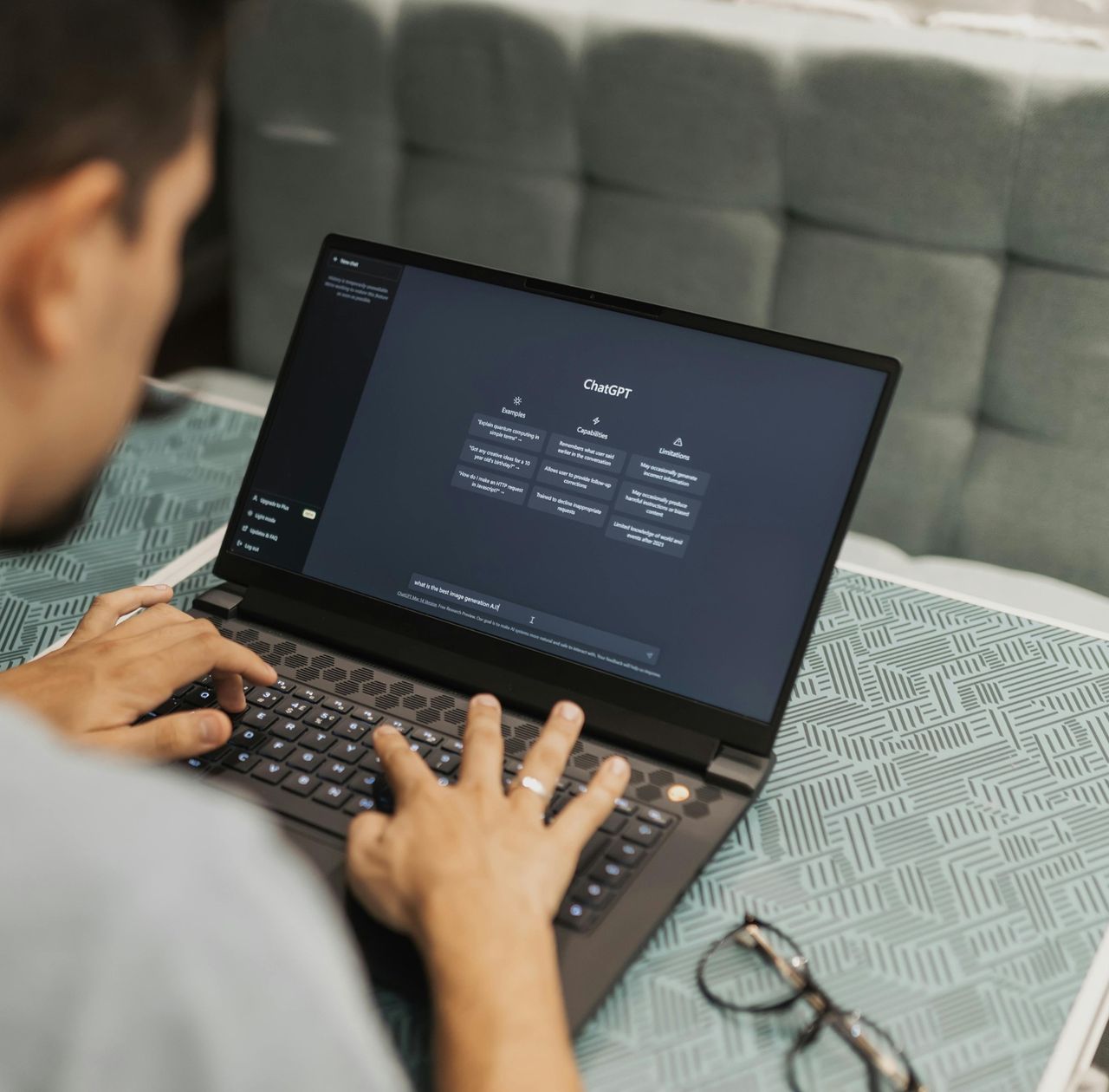 Person typing a question into ChatGPT on a laptop, showing how customers search with AI