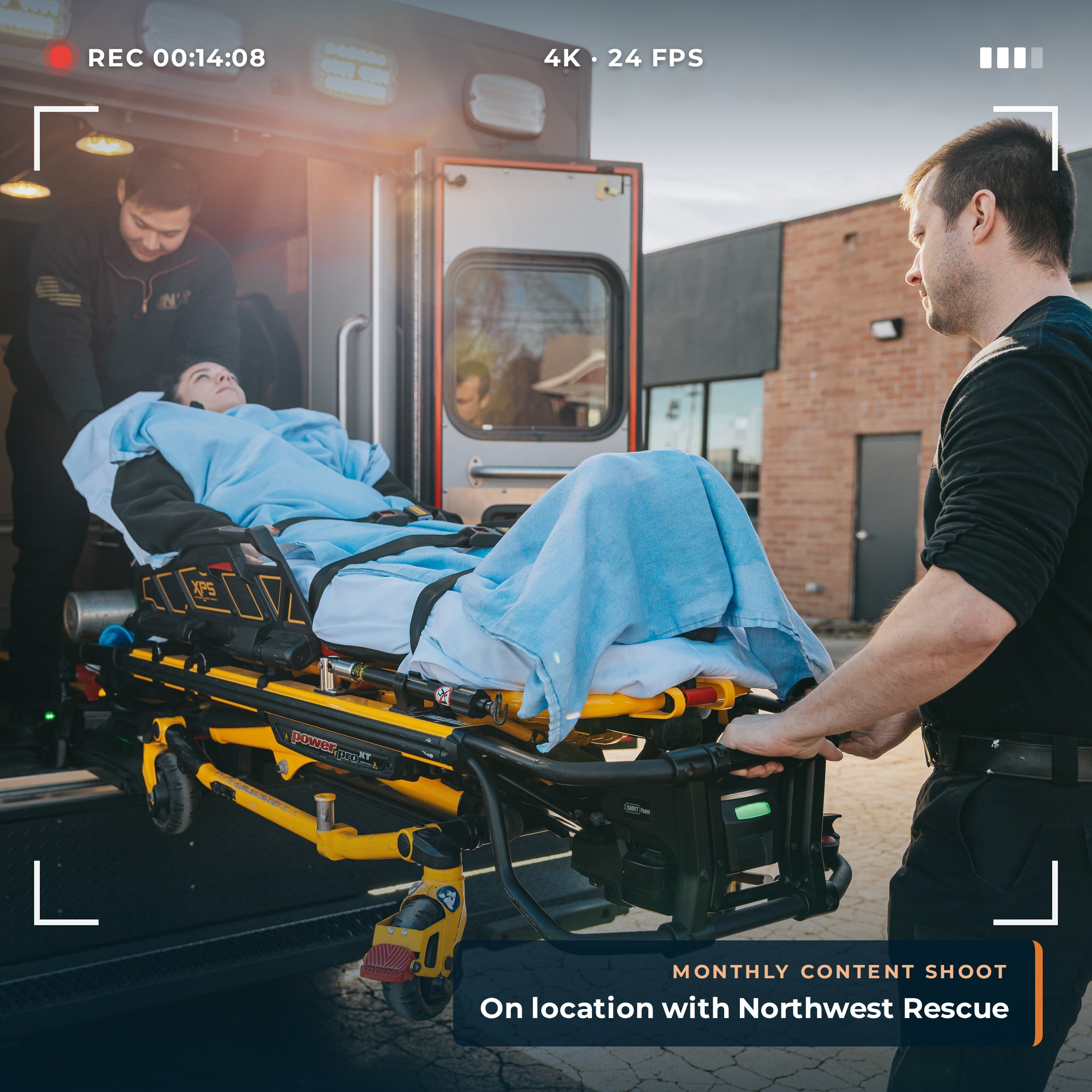 Camera viewfinder recording Northwest Rescue EMTs loading a patient into an ambulance during an on-location content shoot