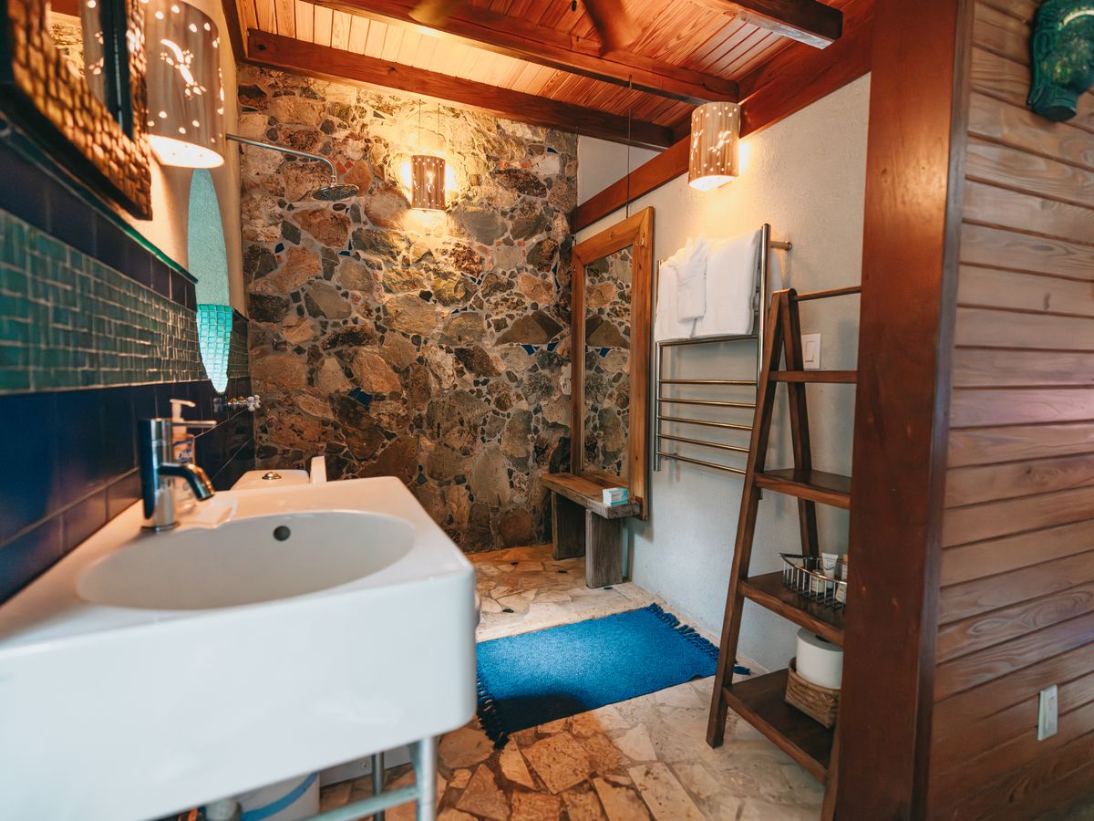 Moon Cottage bathroom with natural stone walls and blue tile