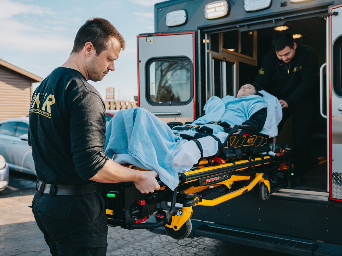 Northwest Rescue paramedic loading a patient on a stretcher into the ambulance