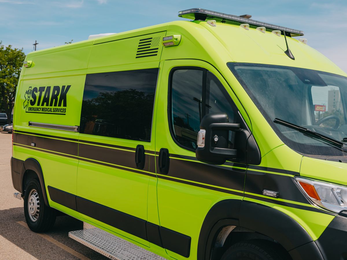 Lime green Stark County Ambulance Ram ProMaster parked outside