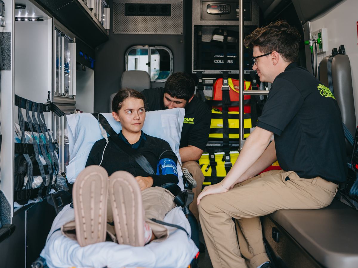 Stark County Ambulance EMT sitting with a patient inside the ambulance