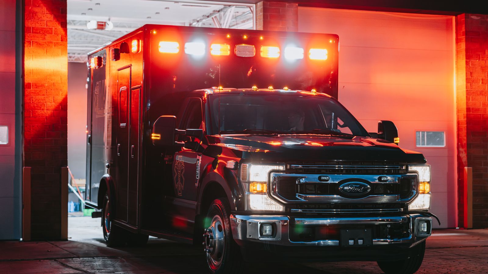 Northwest Rescue ambulance with emergency lights glowing in the station bay