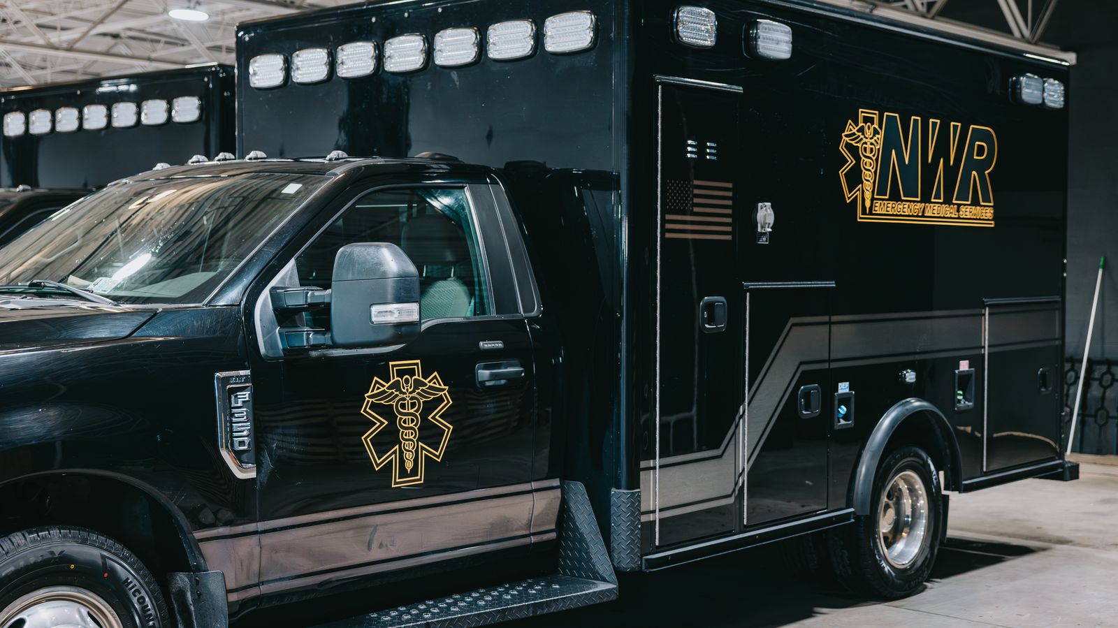 Row of black Northwest Rescue ambulances parked in the fleet garage
