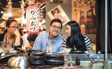 Couple enjoying a cozy night out at a Japanese izakaya bar