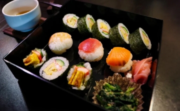 Assorted sushi rolls and nigiri beautifully arranged in a traditional bento box