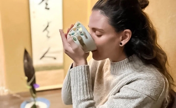 A woman enjoying a traditional Japanese tea ceremony in a serene setting