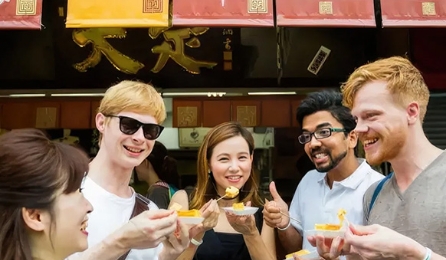 Group of friends enjoying local street food at a traditional Japanese market.