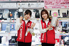BicCamera staff members showcasing beauty appliances with friendly smiles