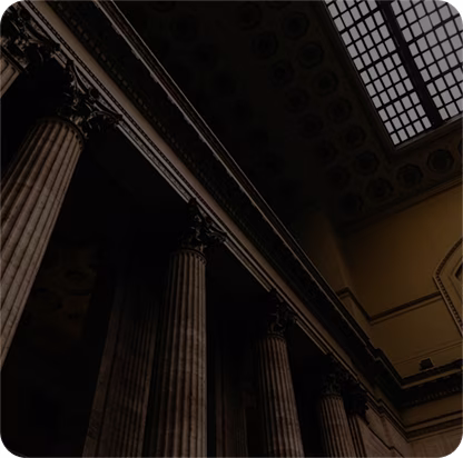 Interior view of classical building columns with ornate capitals and a skylight ceiling above.