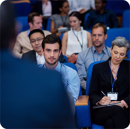 Sunlight shining between tall glass skyscrapers in a city skyline shot from below.