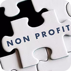 White puzzle piece with the words 'NON PROFIT' on top of other black and white puzzle pieces.