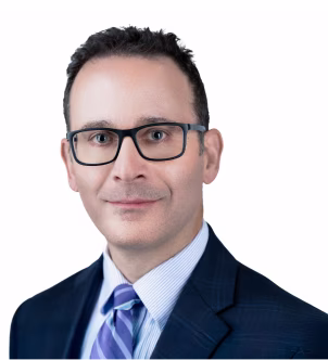 Smiling middle-aged woman with shoulder-length white hair wearing a dark blazer.