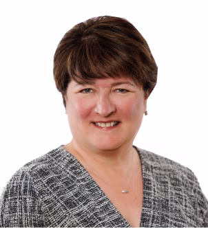 Smiling woman with short dark hair wearing a red top against a plain gray background.