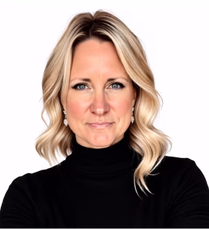 Smiling woman with long dark hair wearing a black blazer and pearl necklace on a white background.