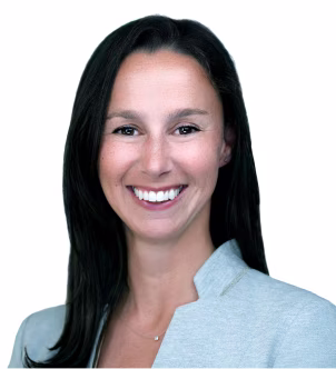 Portrait of a smiling woman with long brown hair wearing a black top against a gray background.