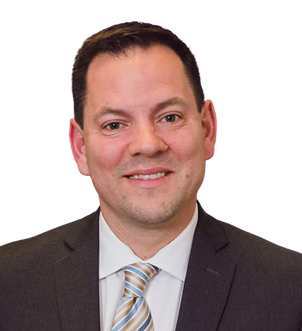 Smiling man in a dark suit, white shirt, and striped tie against a white background.