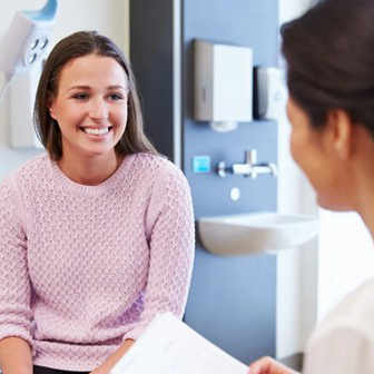 Doctor consulting with a young female patient about breast health