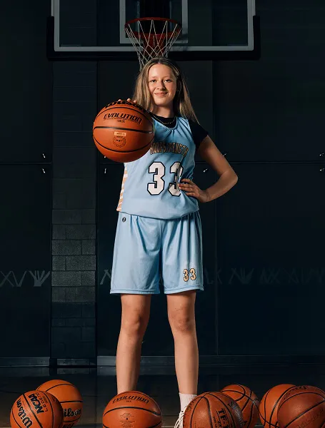 Calgary youth female basketball player from HoopStrength posing confidently with a basketball during a Media&Motion sports media day.