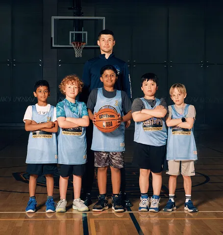 Calgary youth basketball coach standing with a group of HoopStrength athletes during a Media&Motion team media day portrait session.
