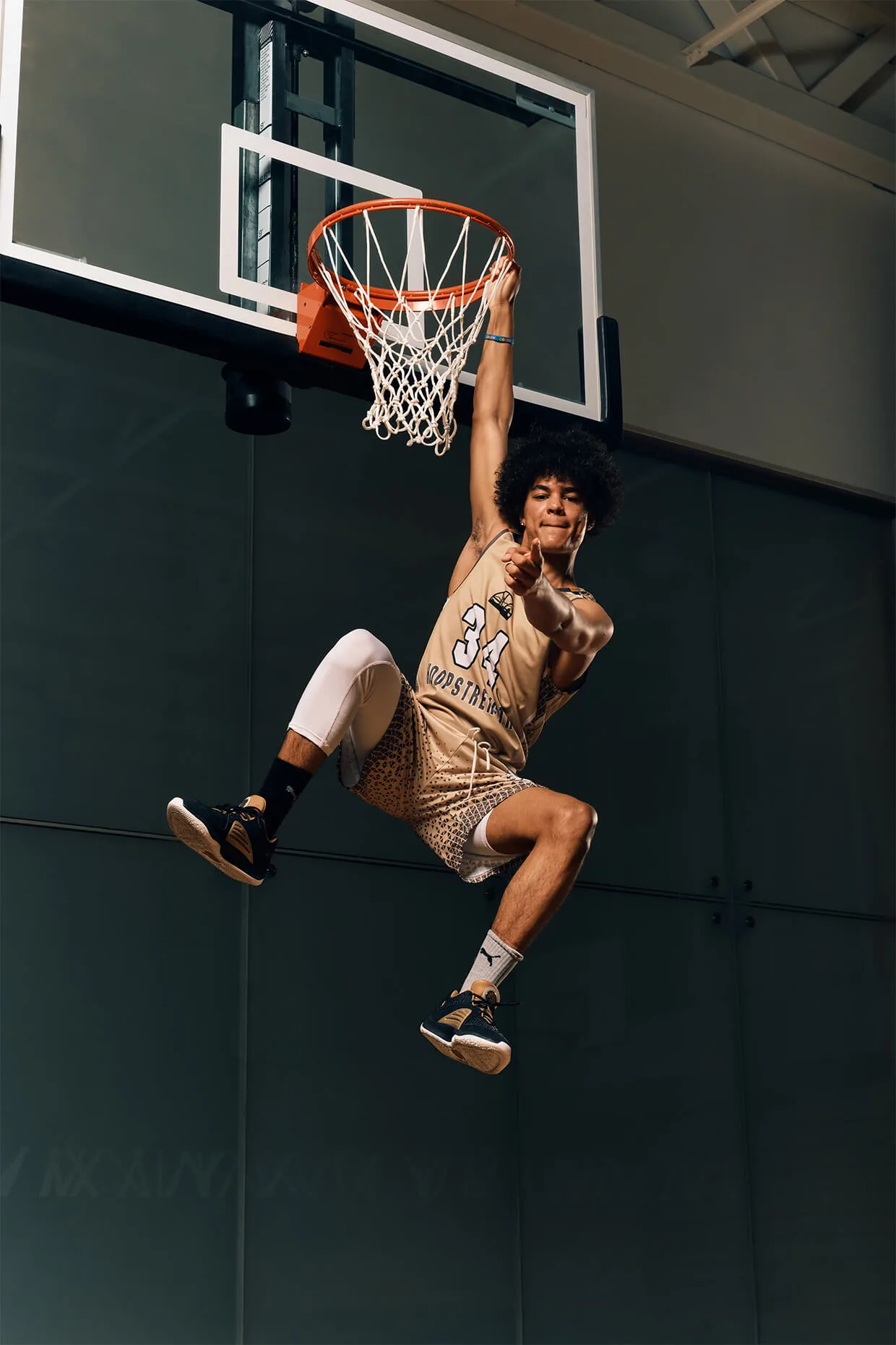 Basketball media day photo showing a player jumping for a dunk with professional lighting and bold branding. Promotional visual for team photography and sports media services in Calgary.