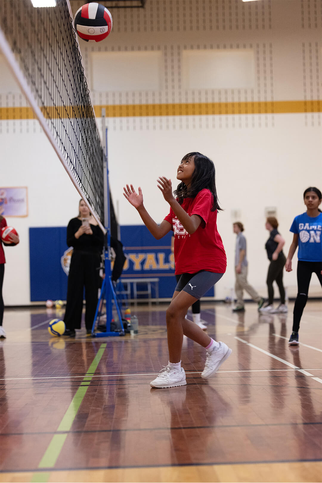 Youth athlete preparing for volleyball set during structured skills practice.