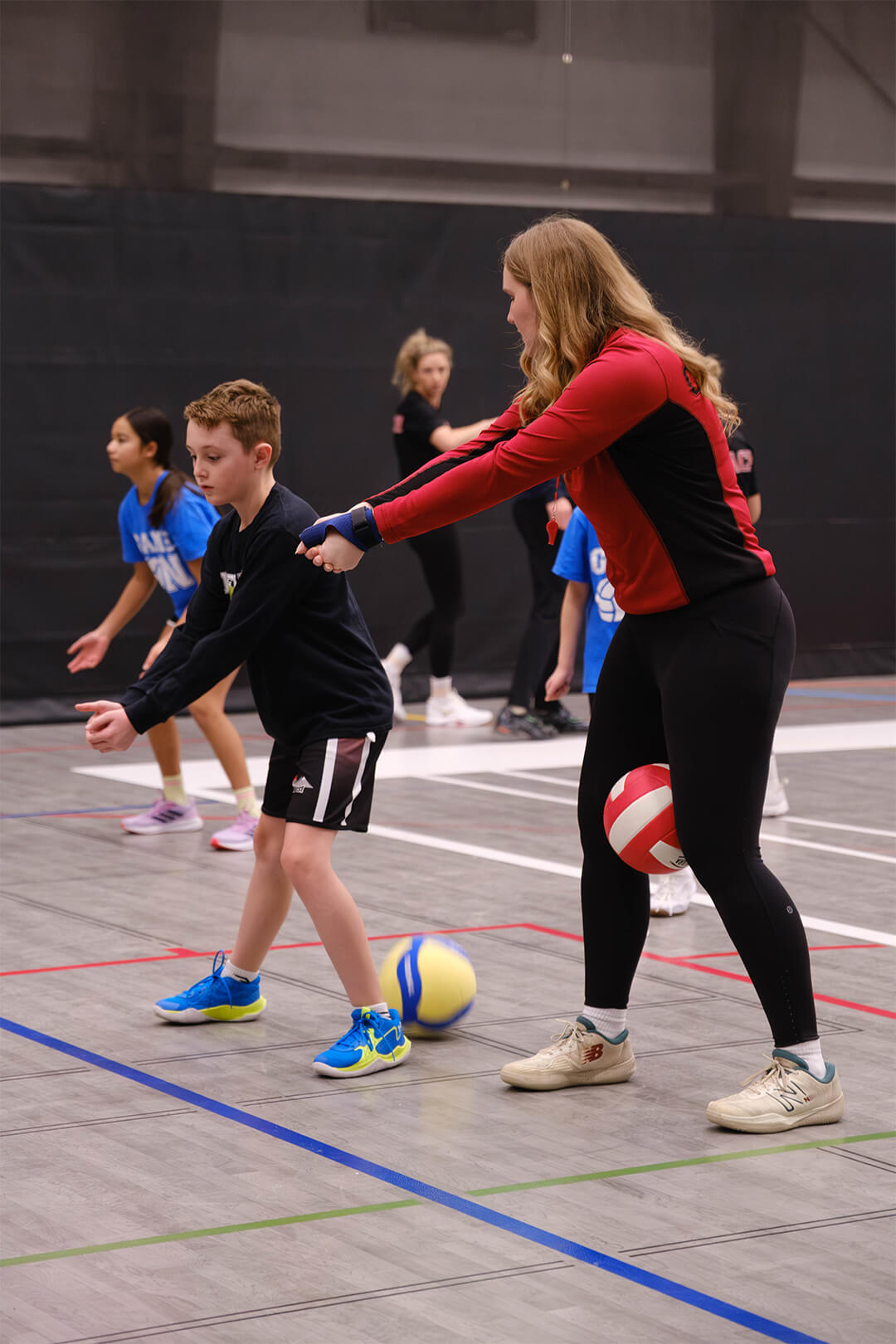 Basketball coach mentoring young athlete during skill-building session at Stryker Sports.