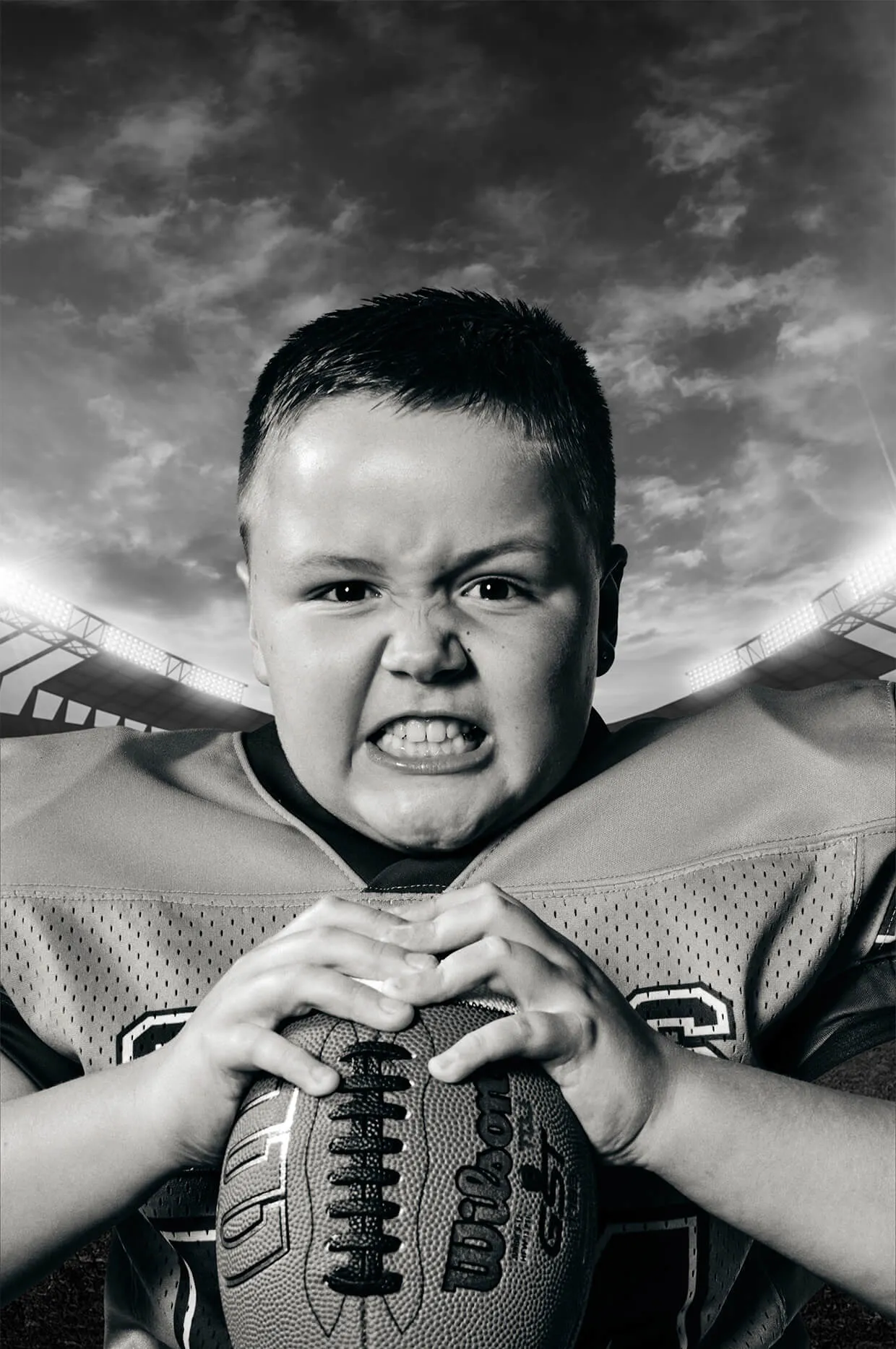 Black and white youth football portrait highlighting competitive expression and strength.