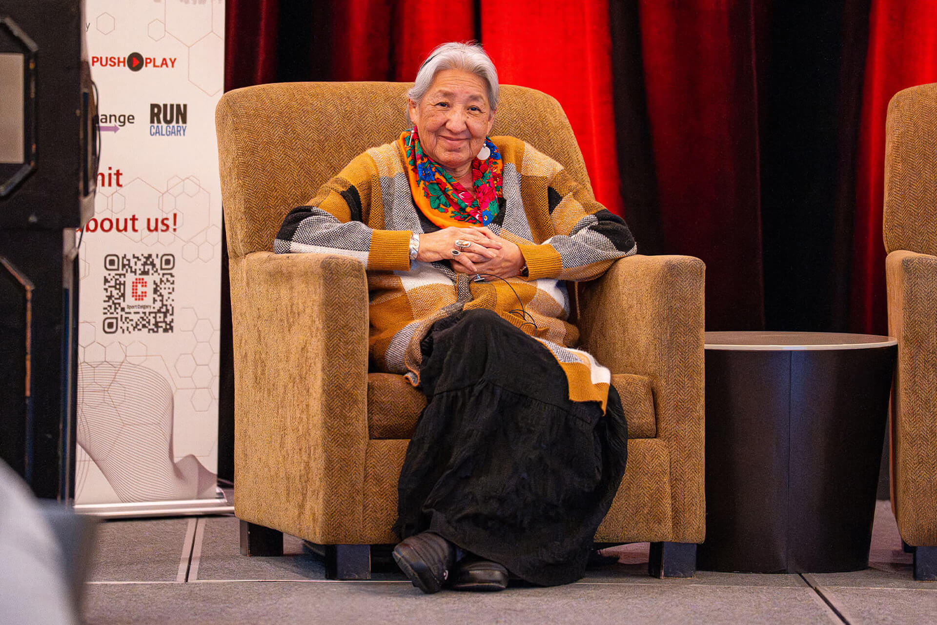 Guest speaker seated on stage during Sport for Life Summit discussion on long-term athlete development.