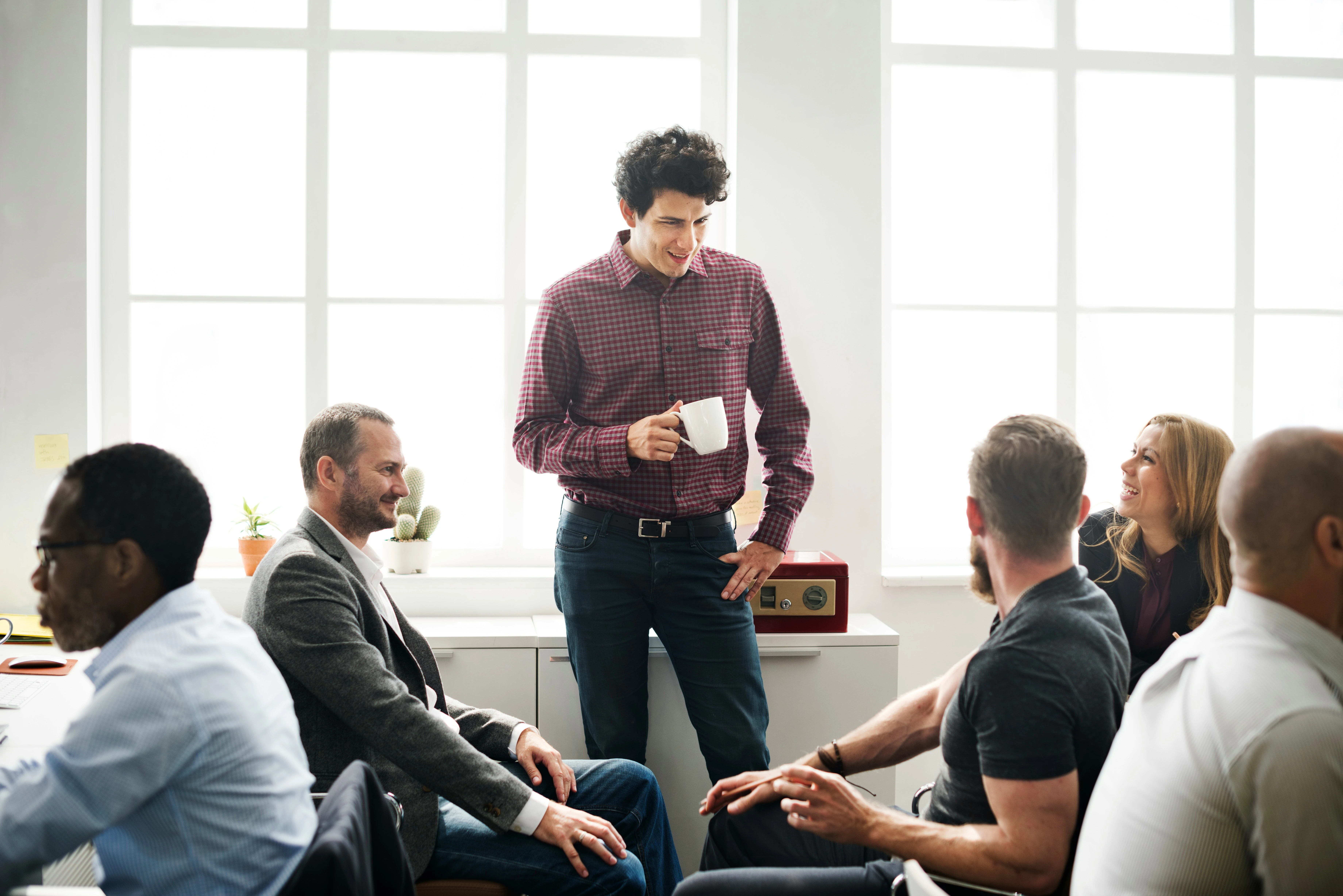 Ein Team tauscht sich in lockerer Atmosphäre bei einem Kaffee aus
