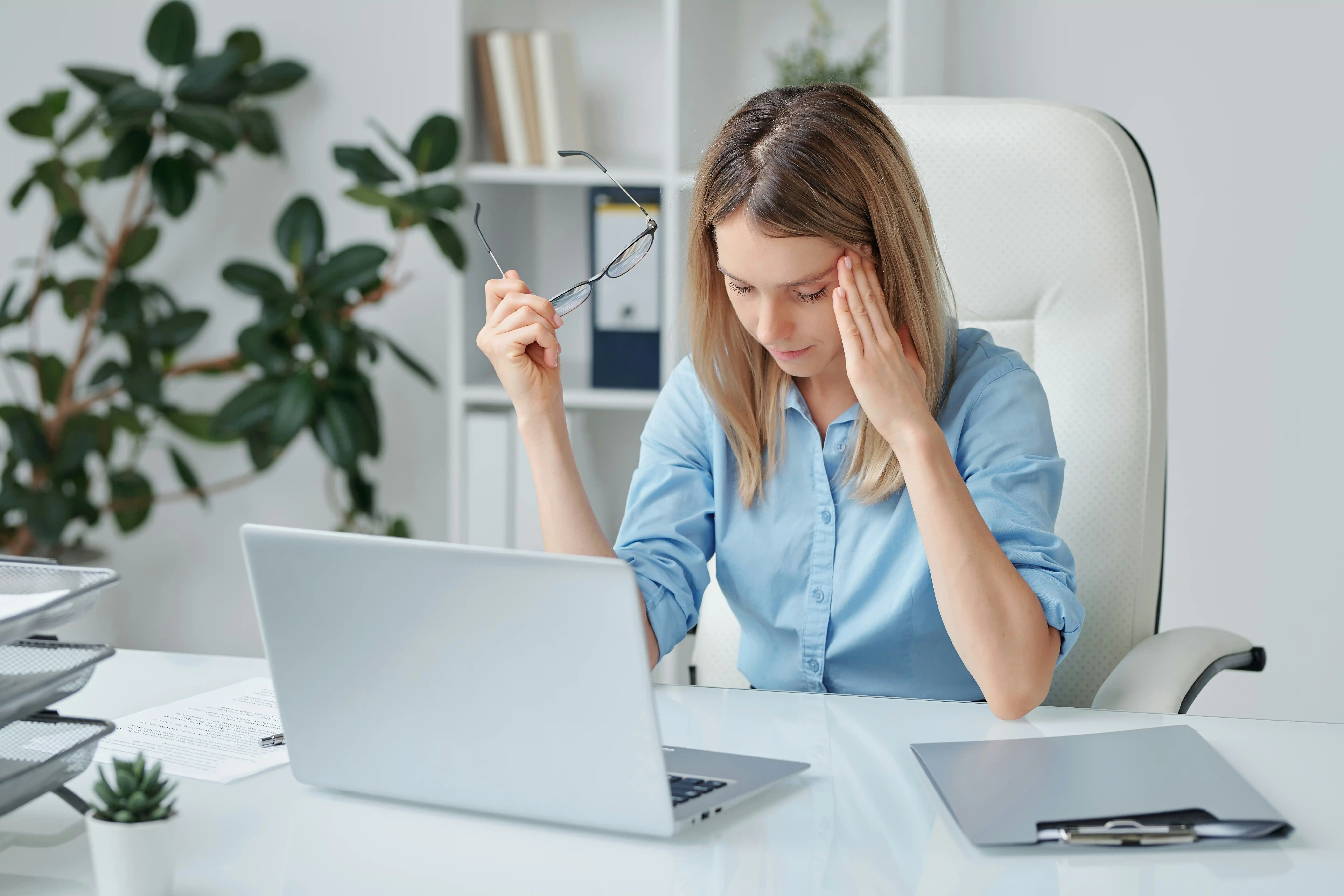 Mitarbeiterin sitzt frustriert vor Laptop