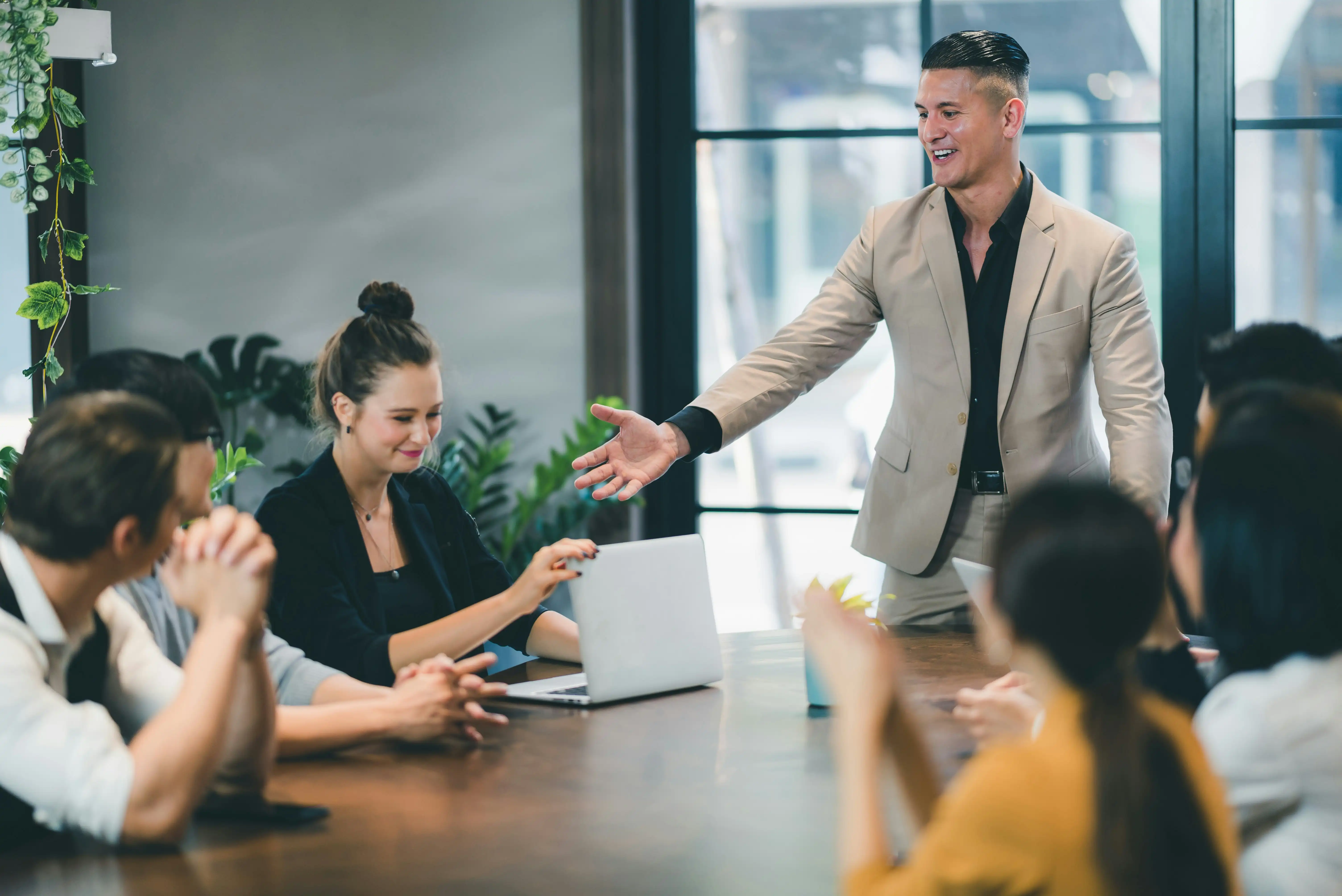 Führungskraft lobt Mitarbeiterin vor dem Team für ihre Leistung