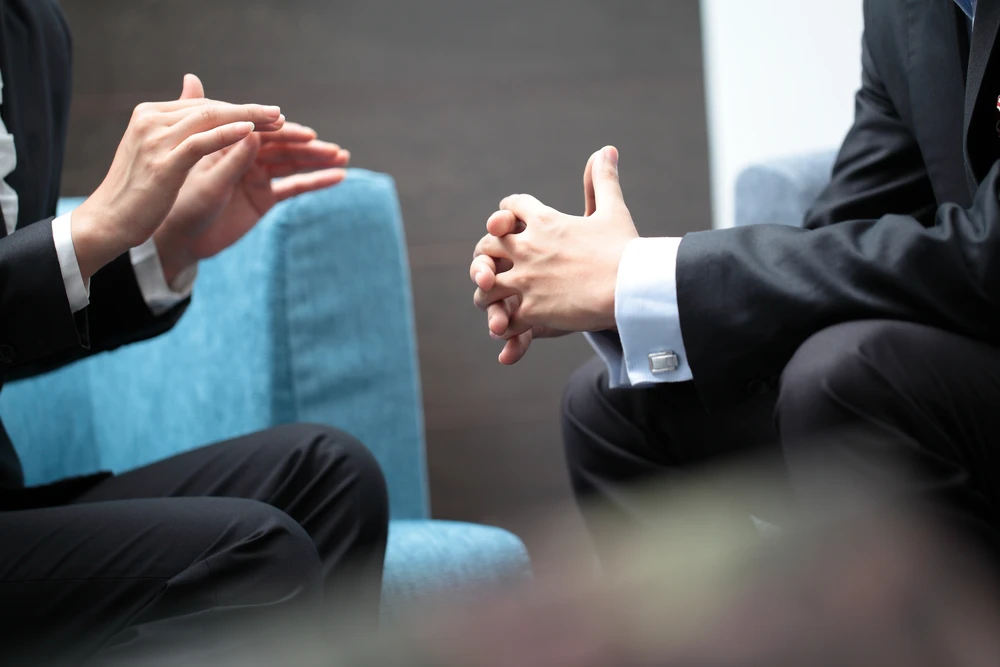 Führungskraft erklärt mit Gestik während Mitarbeiter zuhört