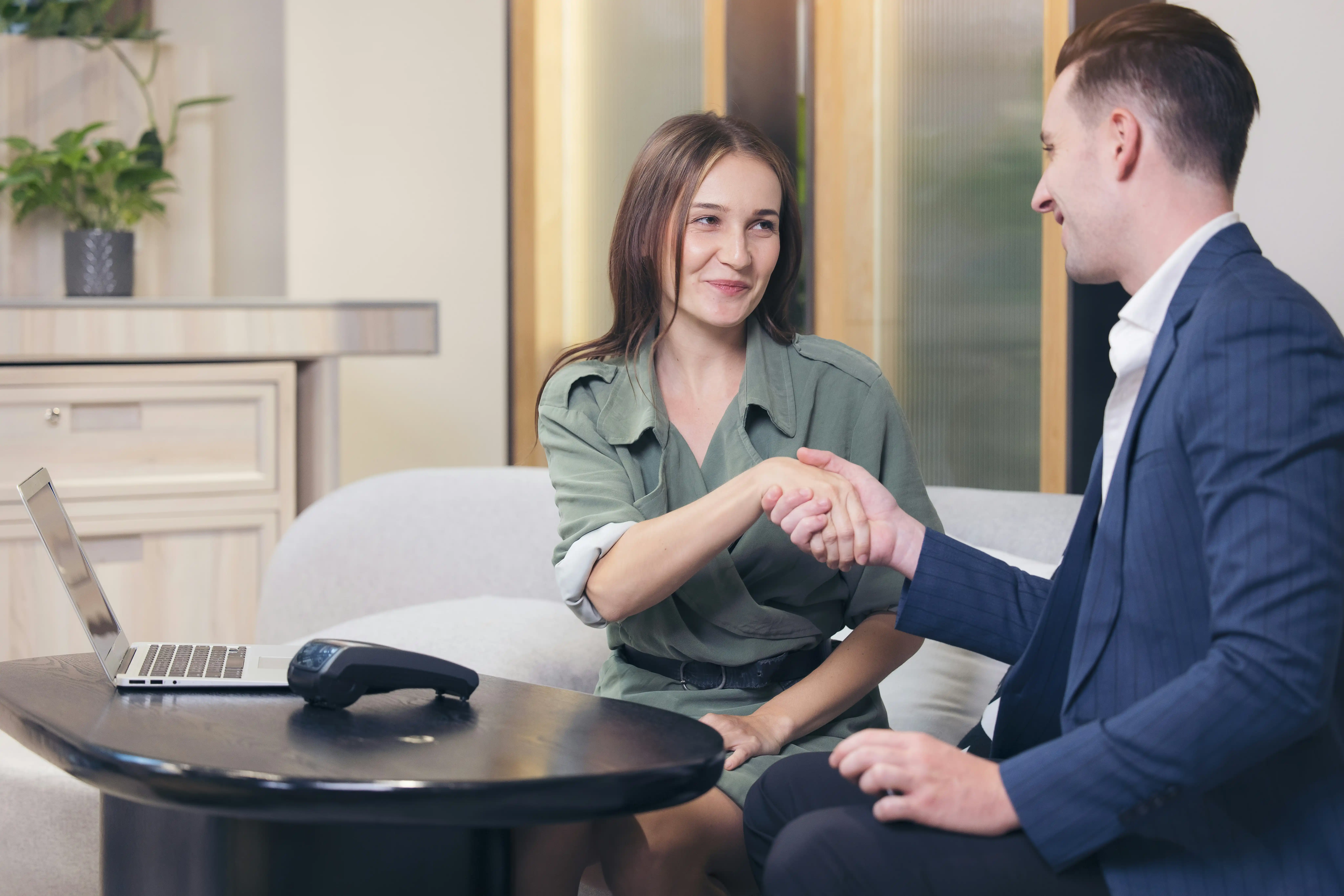 Mitarbeitern und Führungskraft schütteln sich die Hände nach wertschätzendem Offboardinggespräch