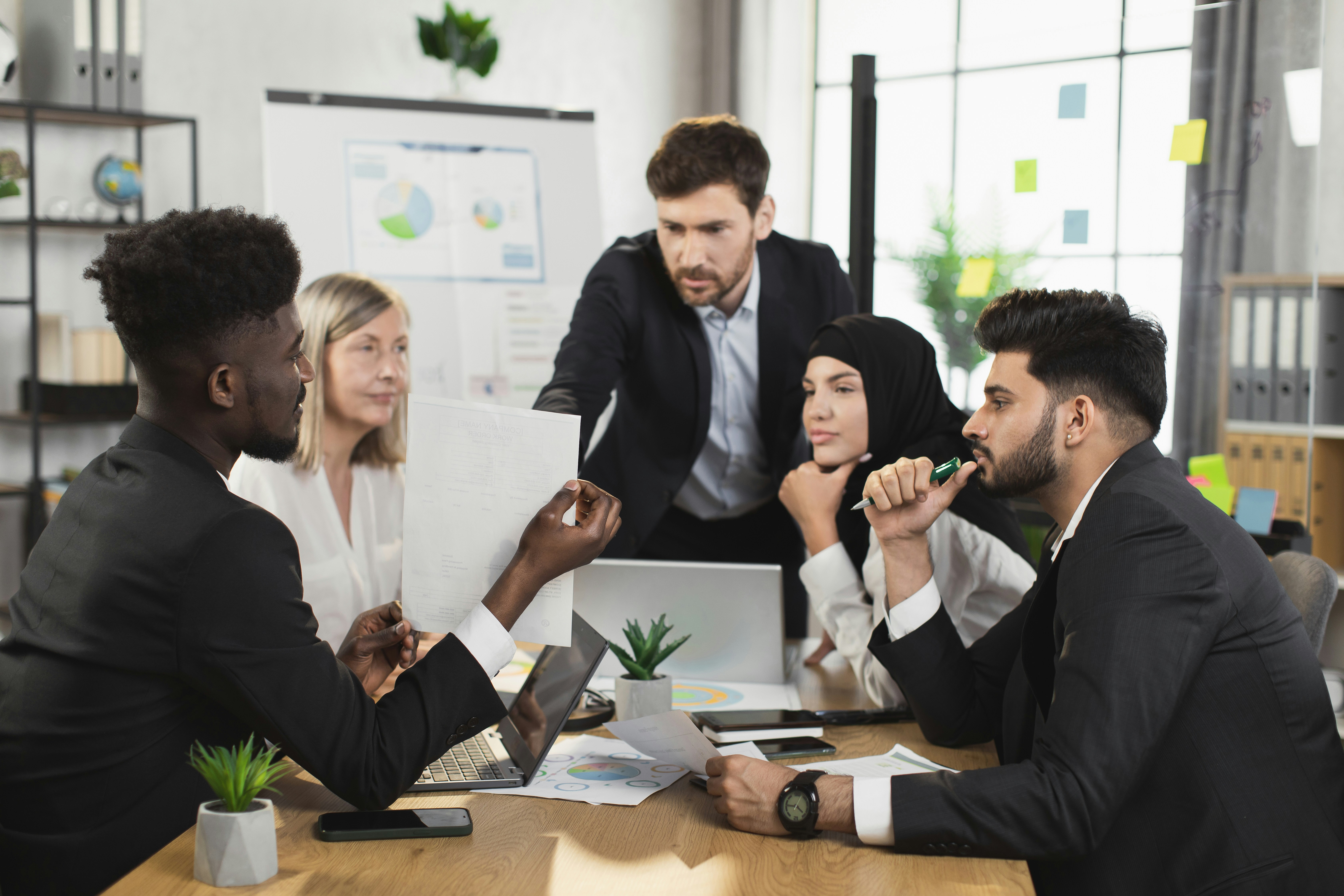 Diverses Team bespricht Unterlagen und Kennzahlen in Meeting