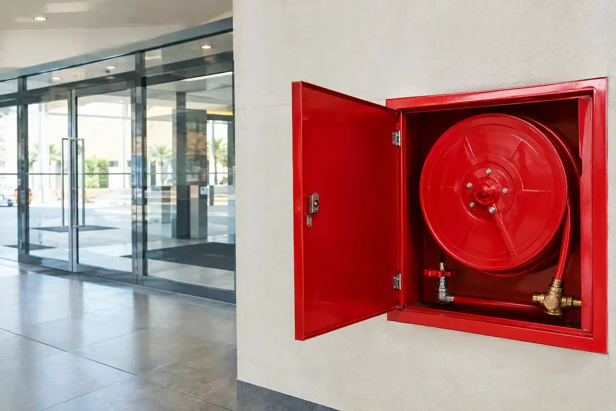 Fire hose reel cabinet mounted on a wall in a multi-store car park