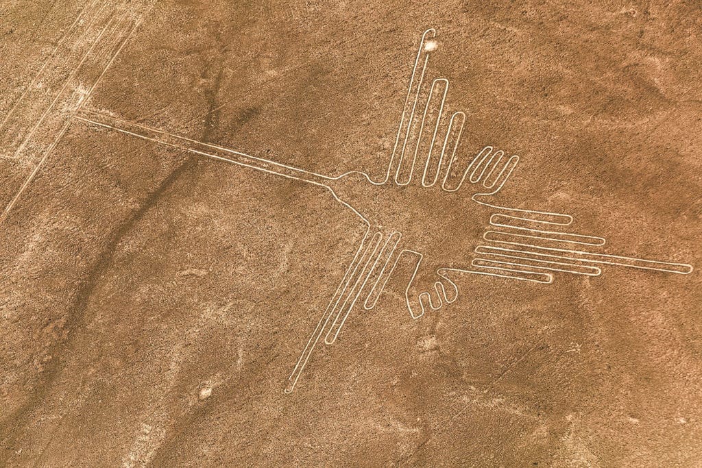 Vue aérienne des lignes de Nazca représentant le colibri, géoglyphes mystérieux tracés dans le désert péruvien.