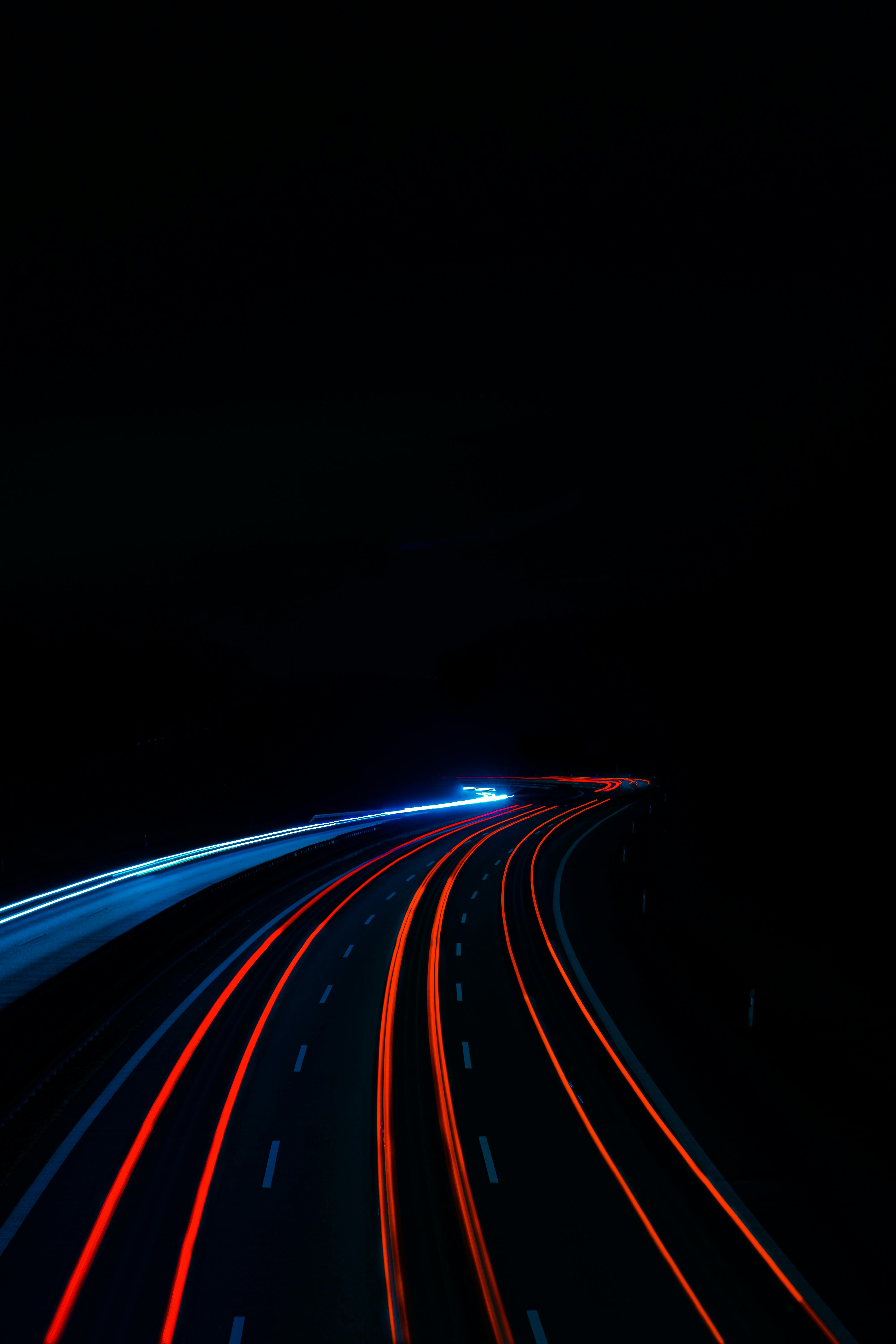 Drei Lagerarbeiter mit Kartons und Paletten in einem Lagerhaus stehend, einer hält ein Tablet.