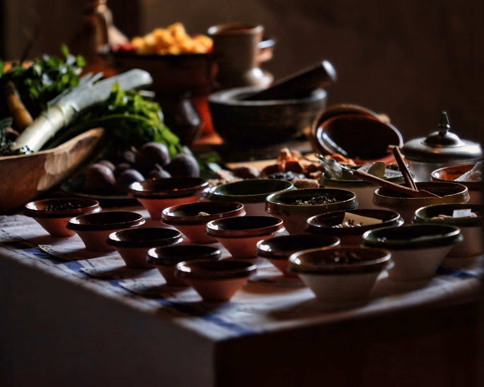 Tazze di ceramica rossa con ingredienti freschi e spezie su tavolo rustico