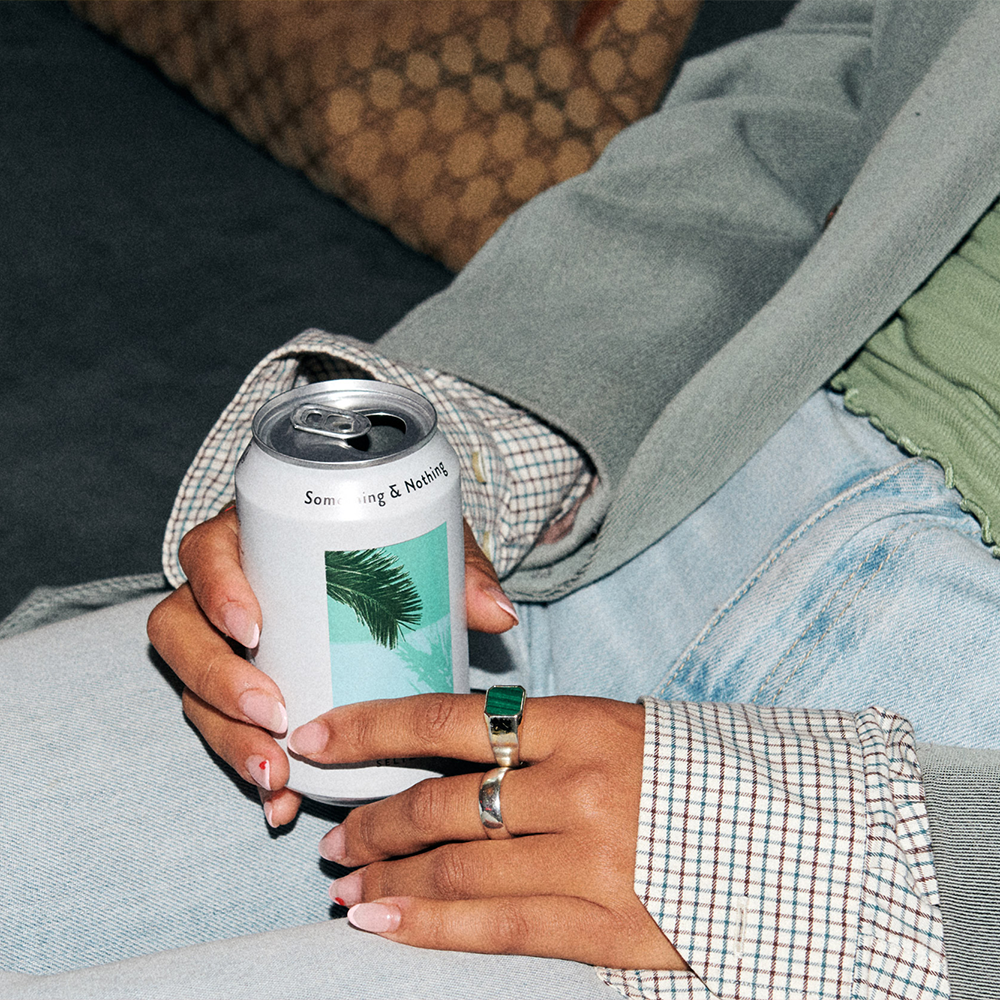 Hands with rings holding a can of something & nothing.