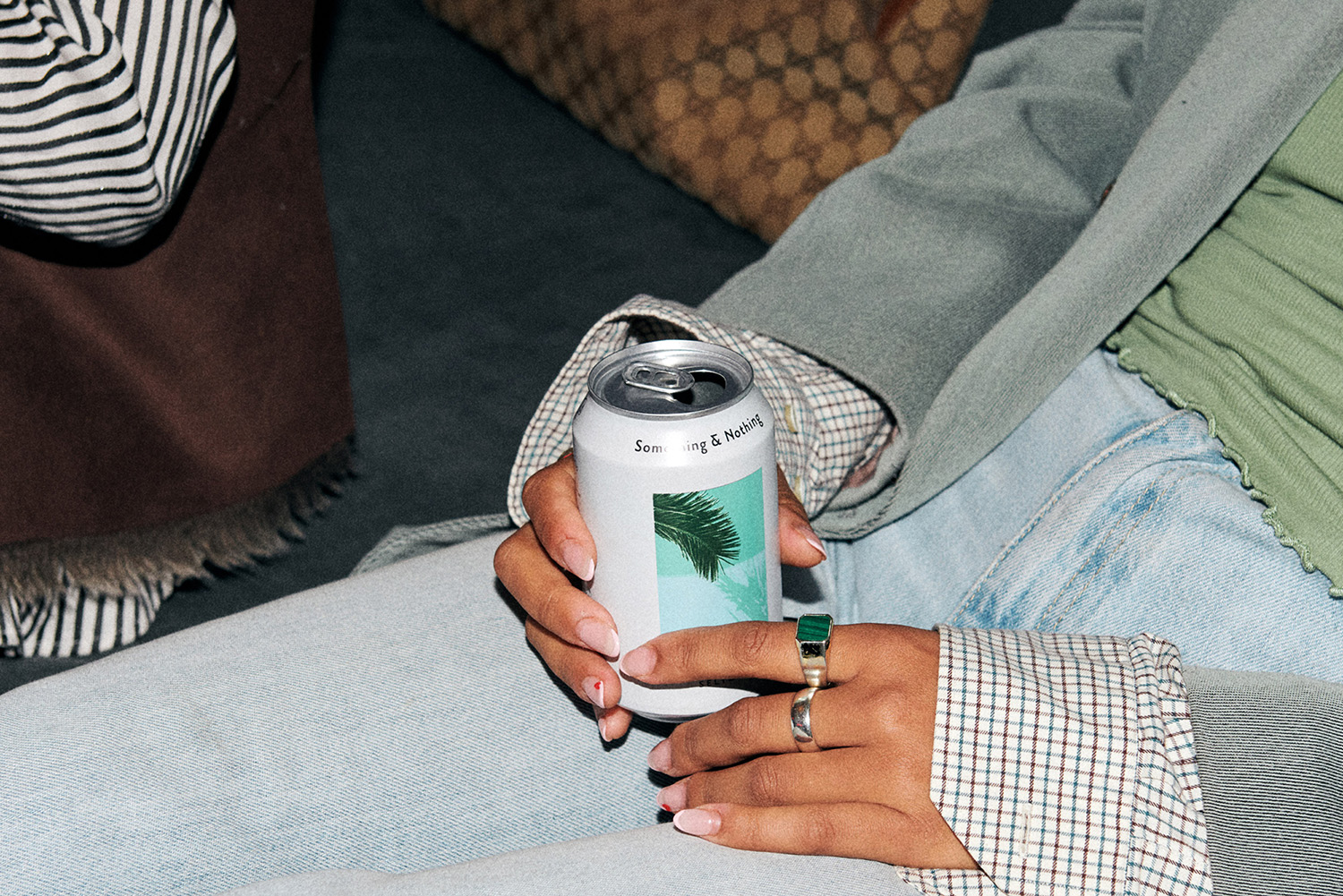 Hands with rings holding a can of something & nothing. 
