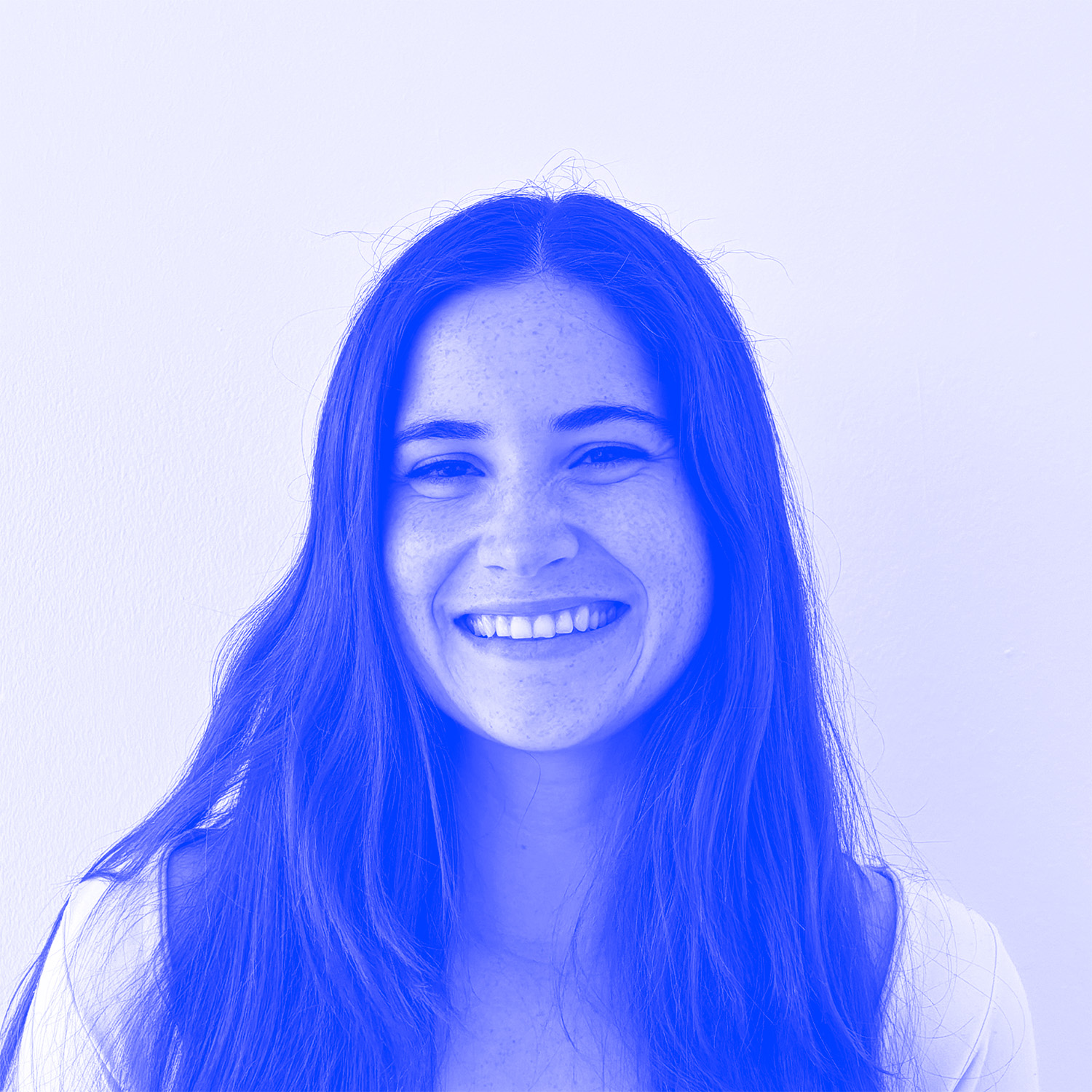 An image of a woman smiling with long brown hair, the image has a blue filter on it. 
