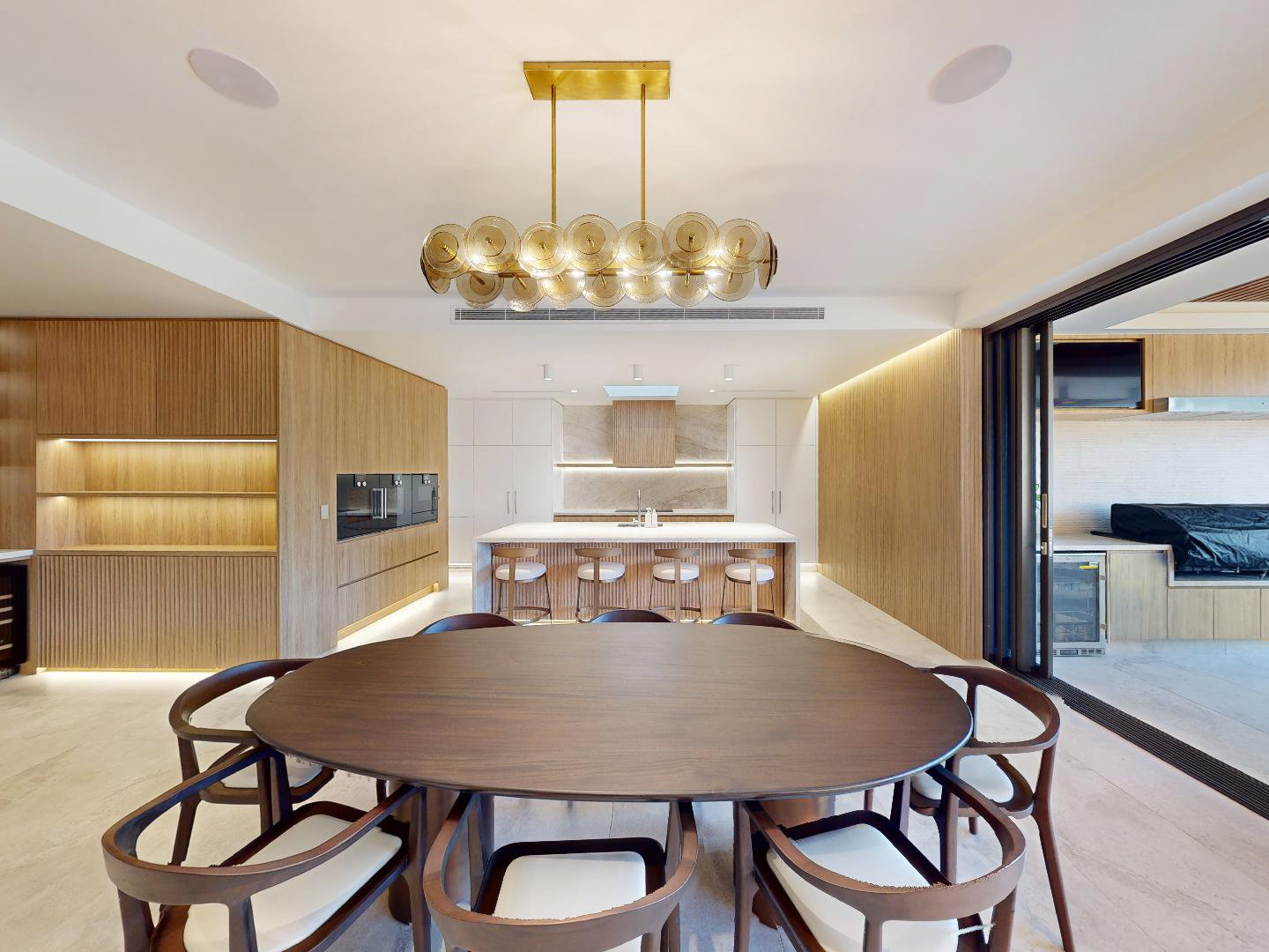 Wide angle photo of a modern, ultra clean wood and white kitchen and dining area.